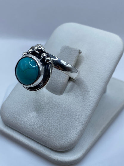 Vista lateral del anillo ajustable de turquesa natural con montura de plata