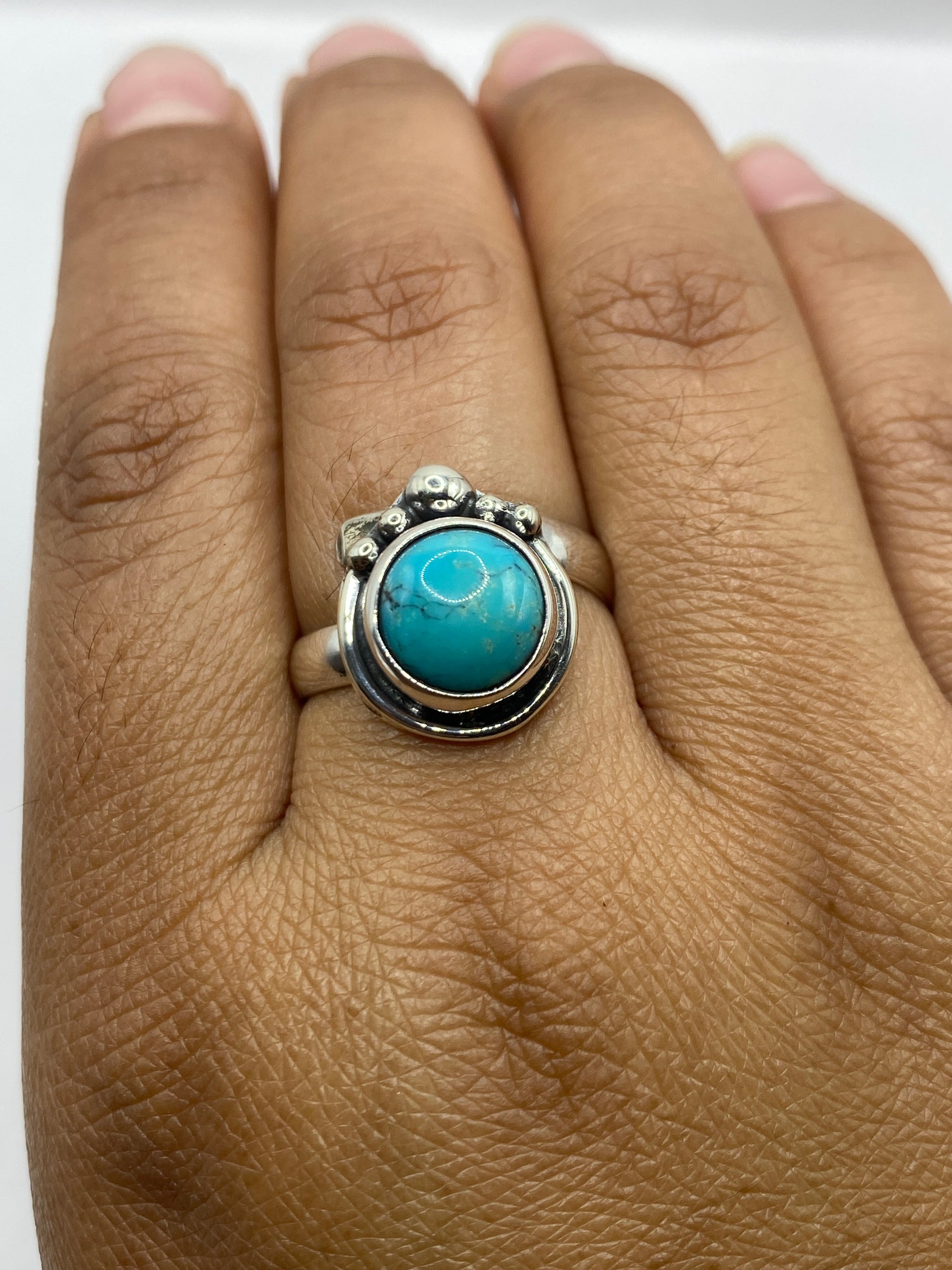 Anillo sobre fondo blanco mostrando el sello .925 y las esferas decorativas de Taxco