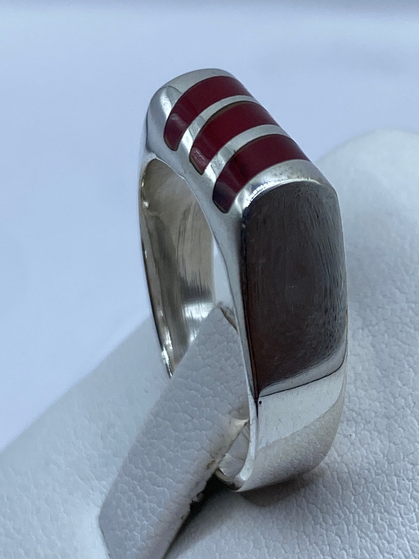 Anillo de coral rojo sobre dedo mostrando presencia y minimalismo