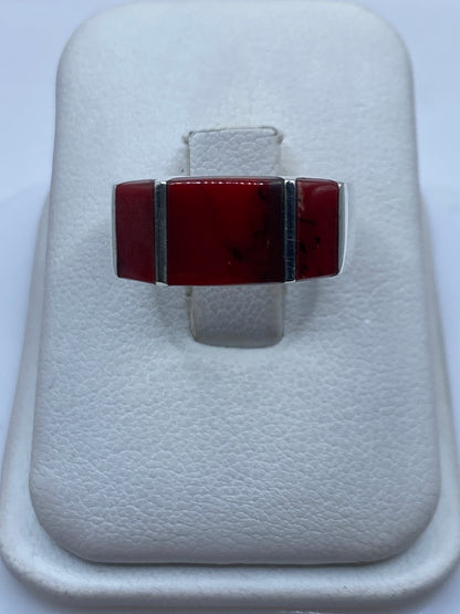 Anillo de plata con coral rojo rectangular en caja de presentación blanca
