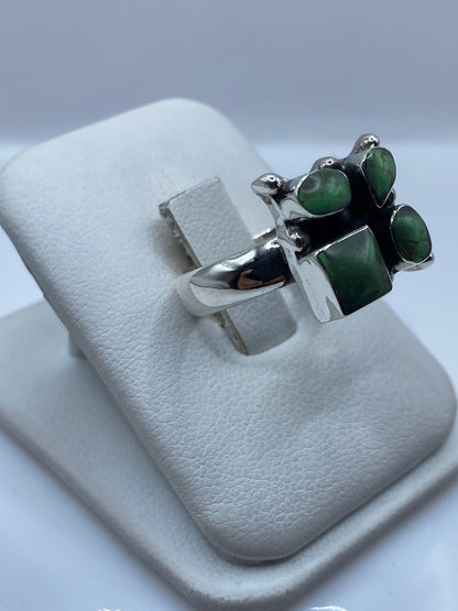 Detalle frontal del anillo mostrando los cuatro cuadrados y óvalos de malaquita engastados en plata