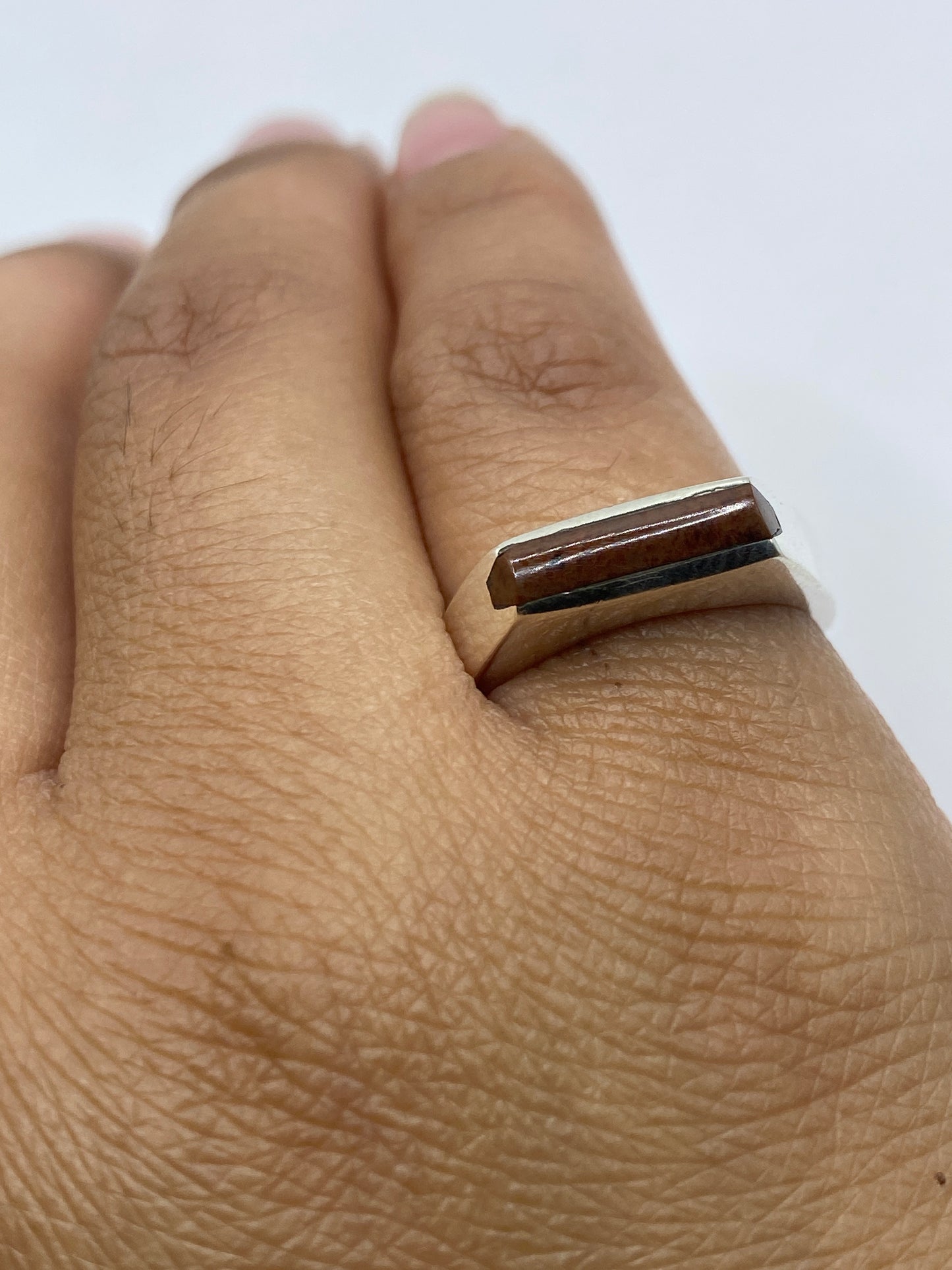 Anillo puesto en dedo mostrando el diseño discreto y la banda ancha