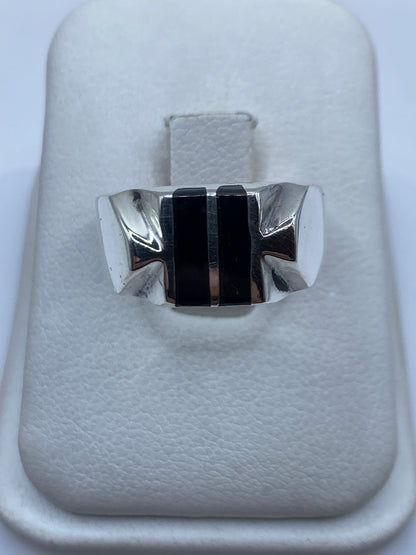Anillo de plata con ónix negro rectangular en centro, bandas arquitectónicas, vista frontal