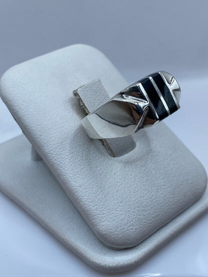Anillo unisex ónix negro en mano de hombre mostrando peso sustancial y presencia