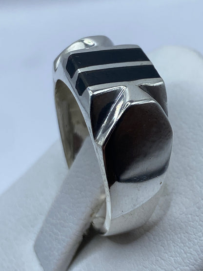 Detalle lateral del anillo con líneas paralelas de plata y ónix pulido