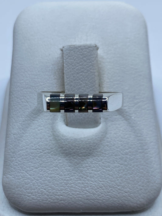 Anillo de plata minimalista con piedras engastadas en la banda, vista frontal sobre estuche blanco