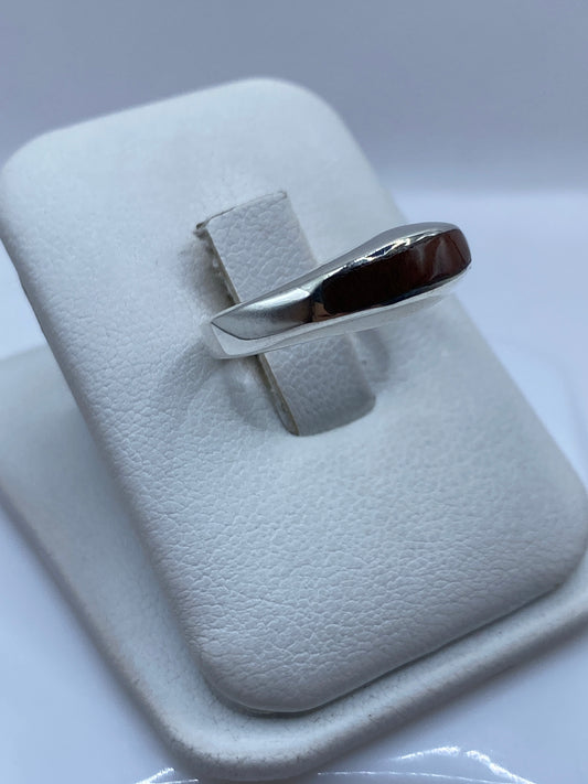 Anillo plata onix café llevado en mano, mostrando el engaste limpio
