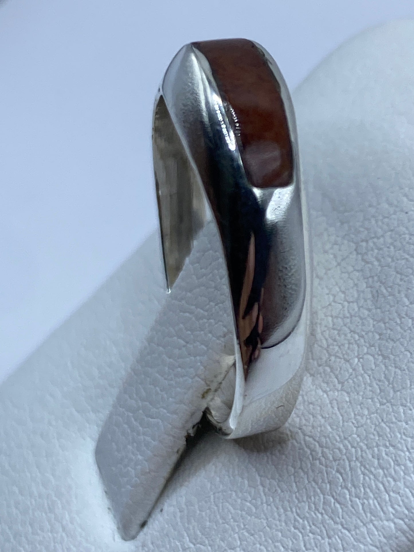Detalle lateral del anillo solitario en plata .925 con piedra oscura