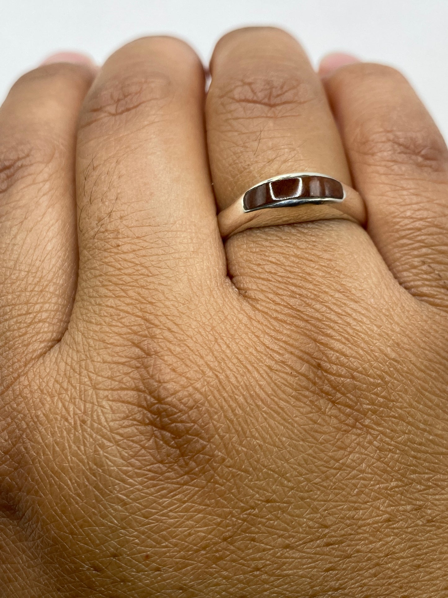 Anillo plata onix sobre escala, mostrando el sello 925 en la banda