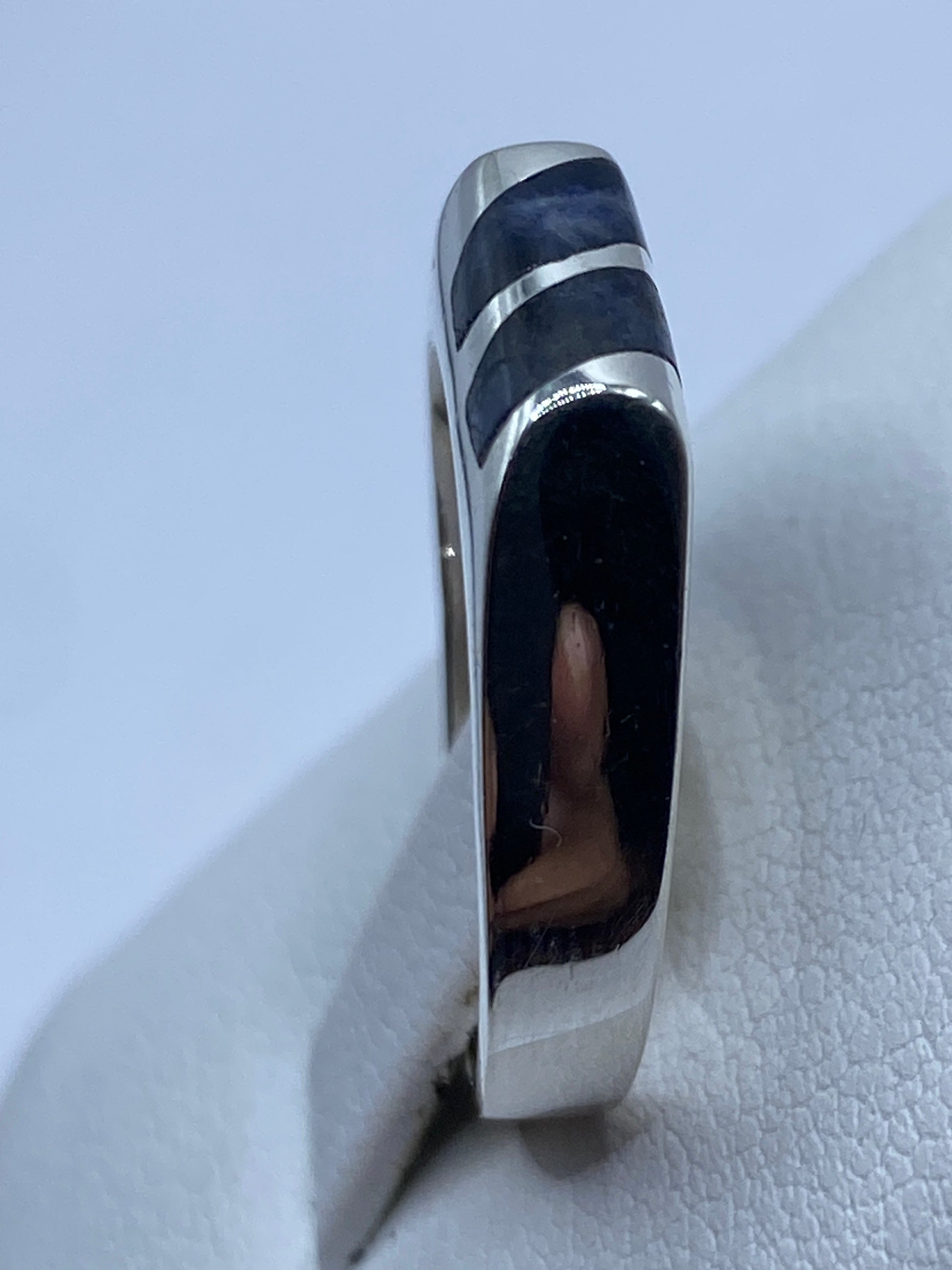 Anillo solitario de plata con lapislázuli azul puesto en mano