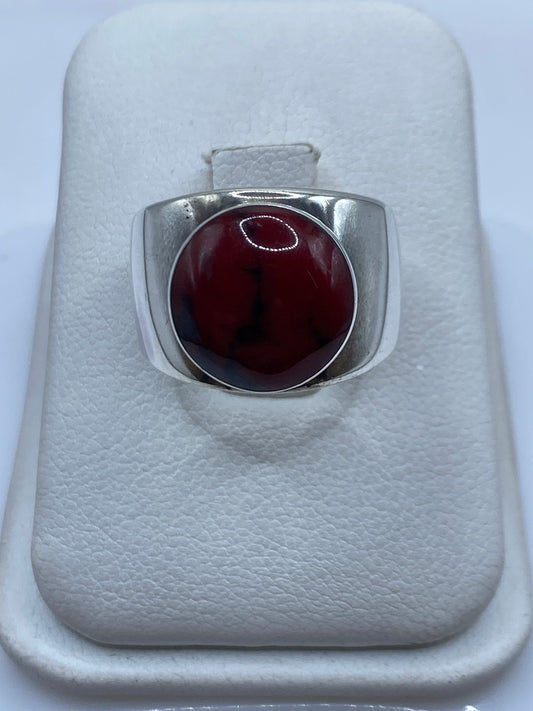 Anillo de plata con coral rojo natural engastado, descansando en estuche blanco