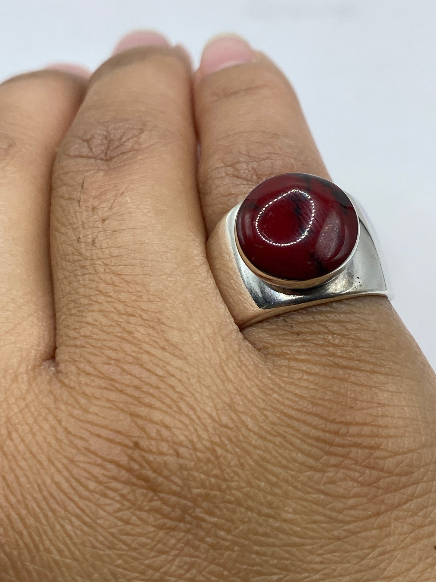 Anillo de coral rojo en dedo, mostrando proporción y presencia de la piedra