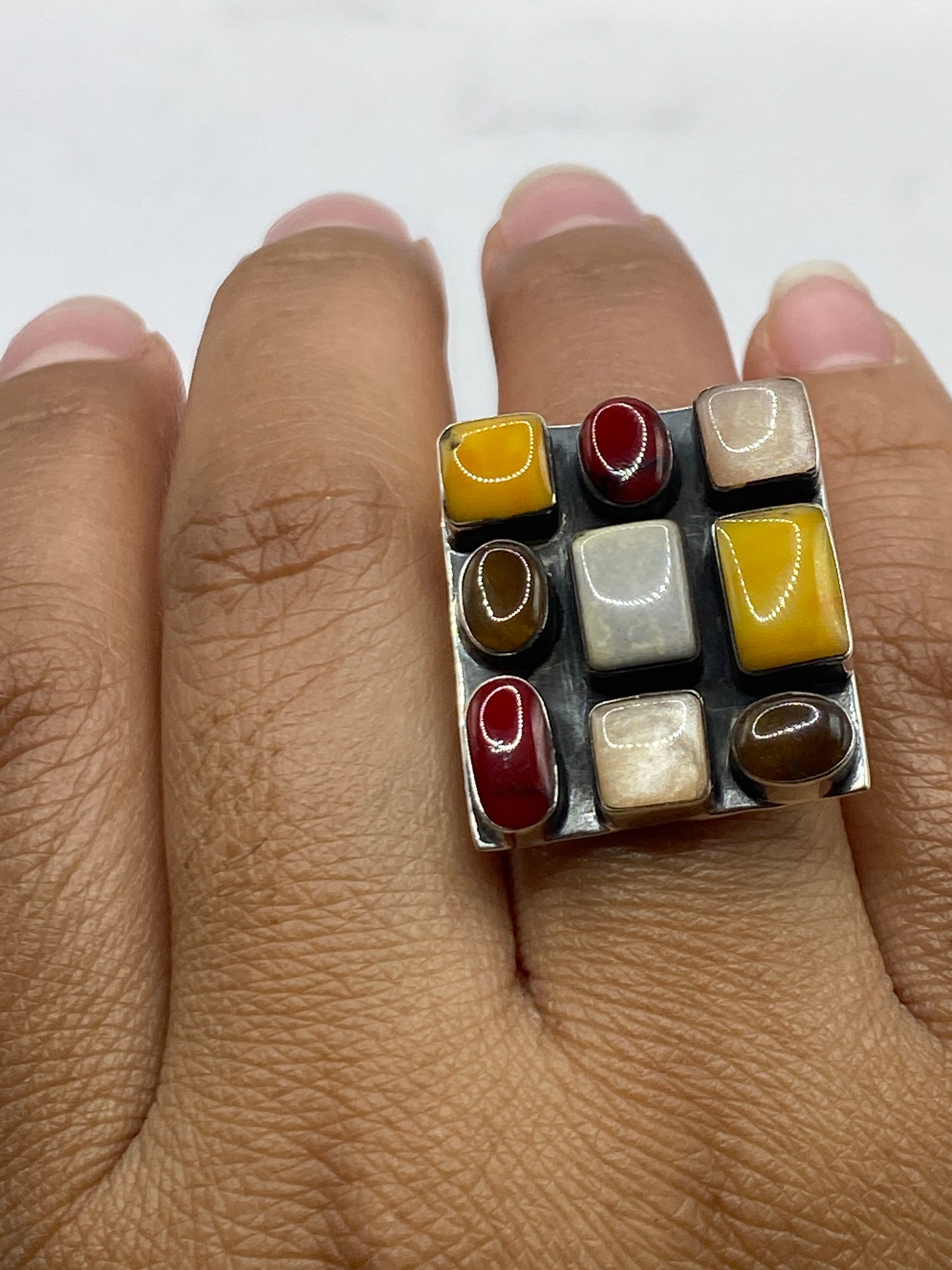 Anillo completo sobre fondo blanco destacando el brillo del coral rojo y pulido de plata
