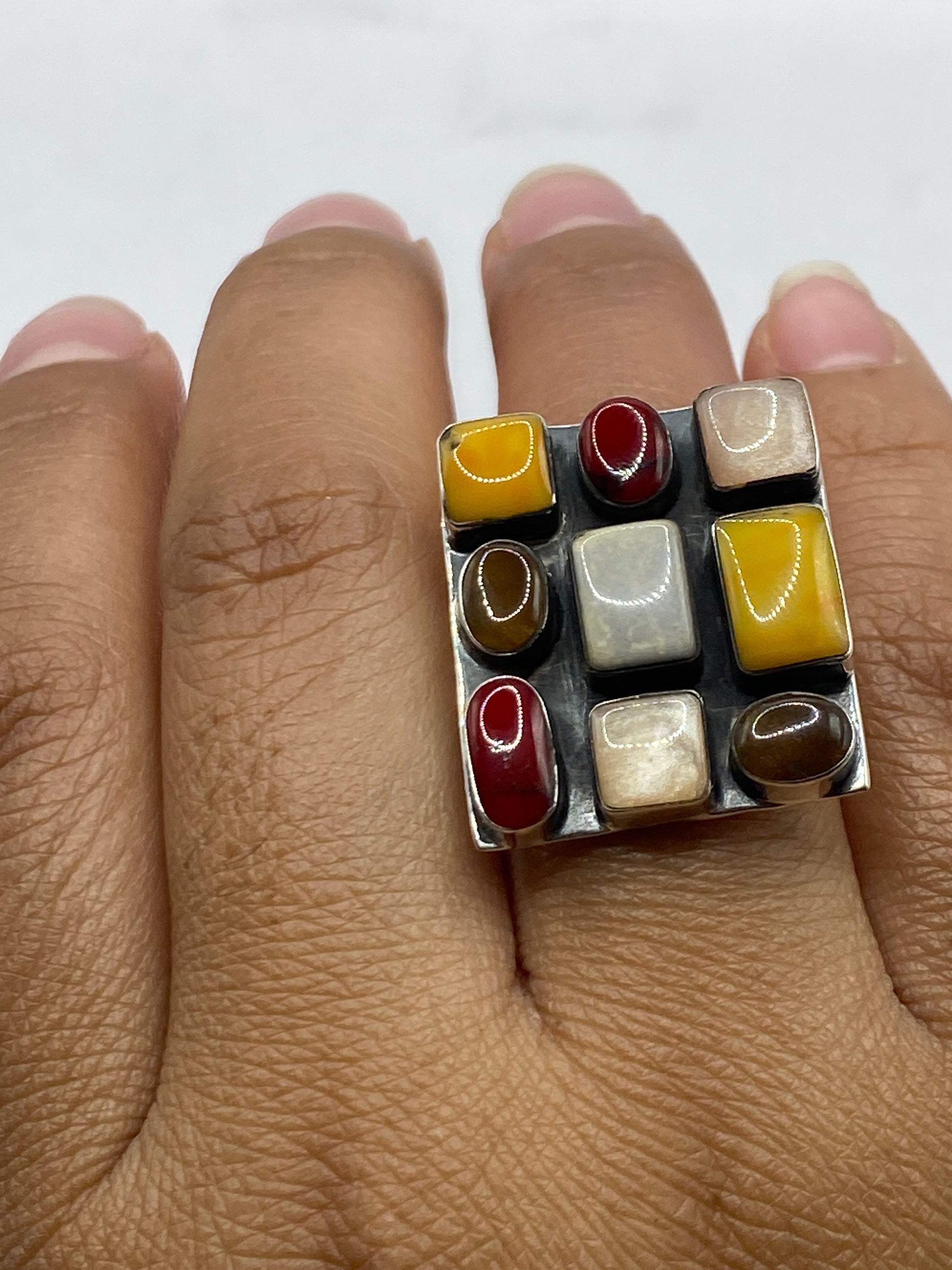Anillo completo sobre fondo blanco destacando el brillo del coral rojo y pulido de plata
