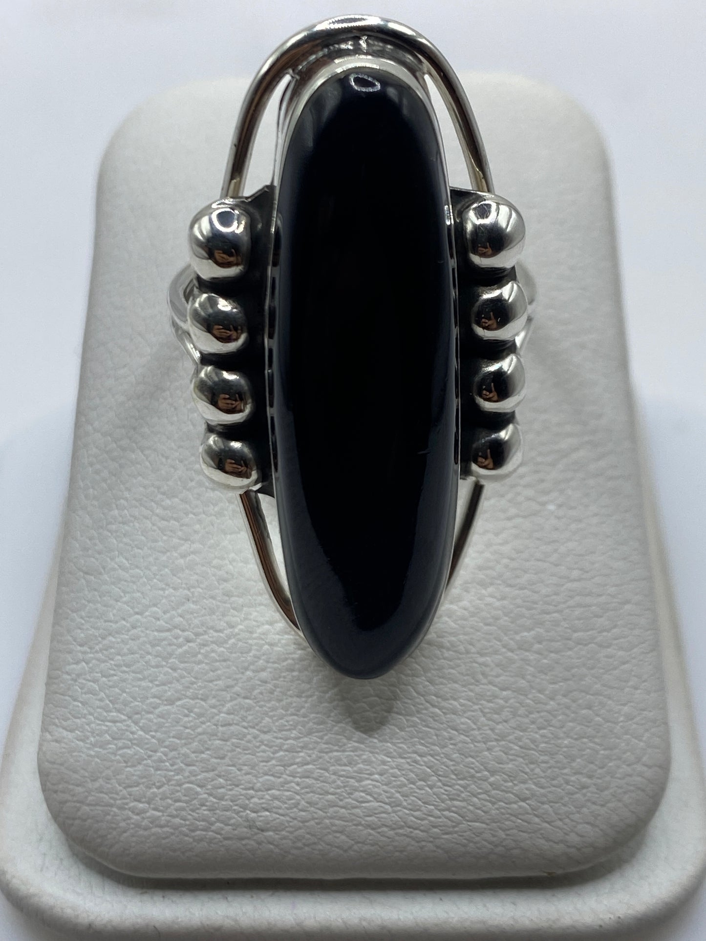 Anillo de plata con ónix negro ovalado y esferas en relieve, frente superior
