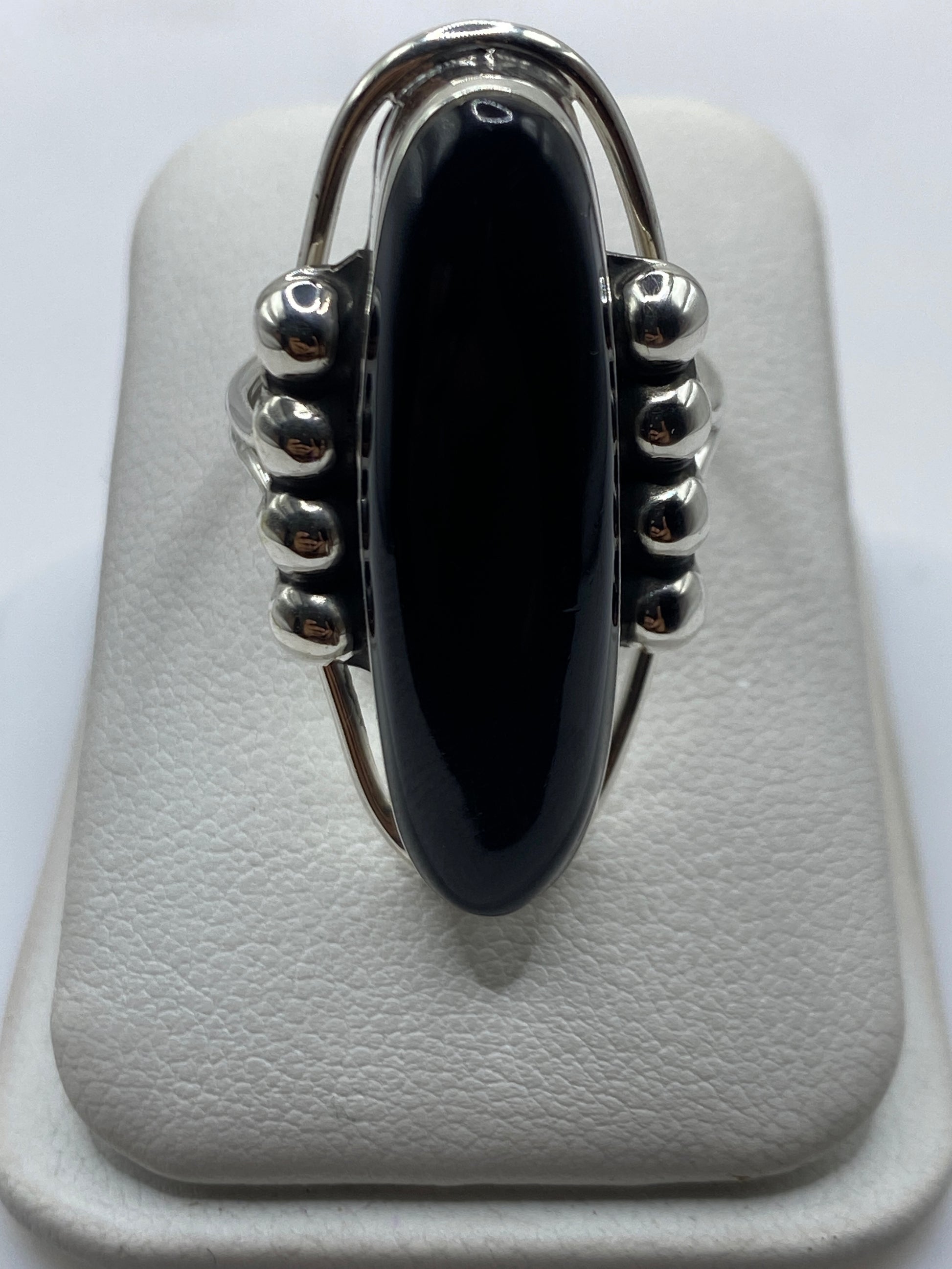 Anillo de plata con ónix negro ovalado y esferas en relieve, frente superior