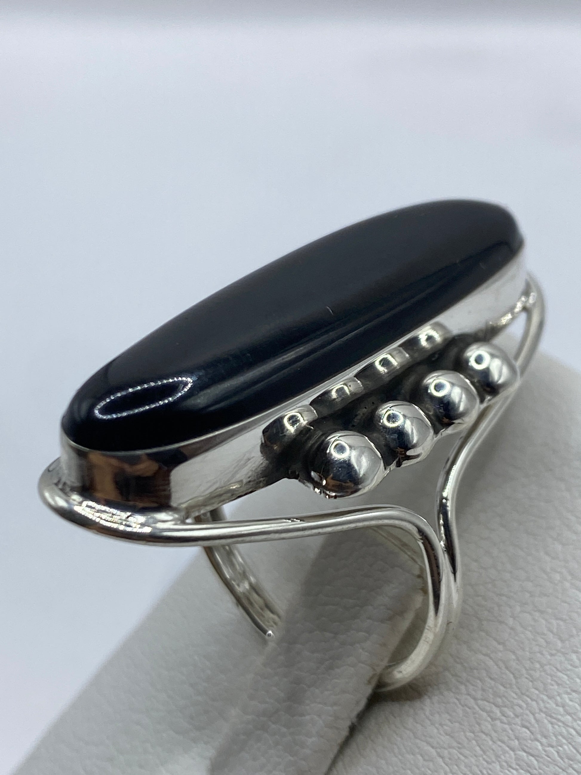 Anillo solitario de ónix visto de lado, mostrando la banda ancha de plata .925