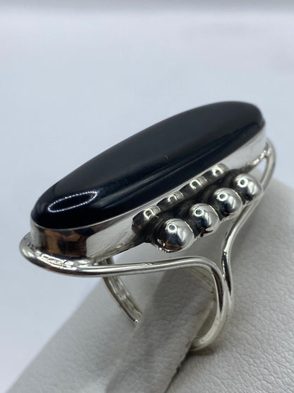 Anillo solitario de ónix visto de lado, mostrando la banda ancha de plata .925
