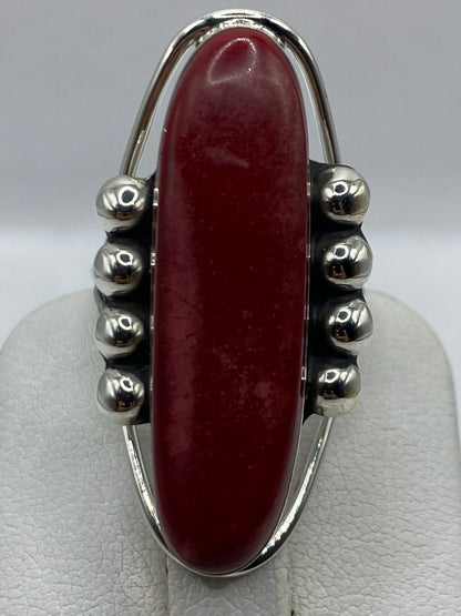 Anillo de coral rojo en la mano mostrando el brillo sedoso del coral