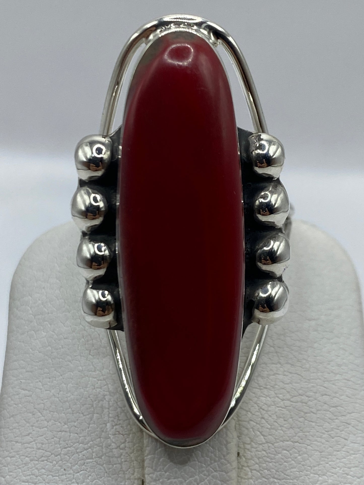 Anillo puesto en dedo mostrando el tamaño y presencia del coral rojo