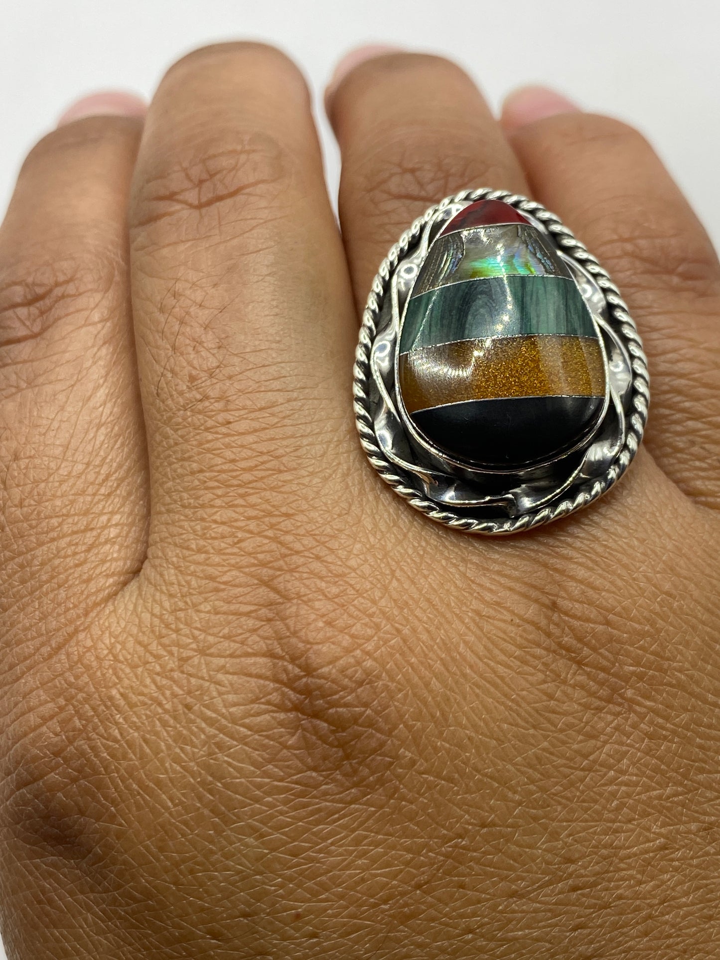 Anillo de malaquita puesto en dedo, mostrando sello 925 MEXICO y el verde profundo de la piedra