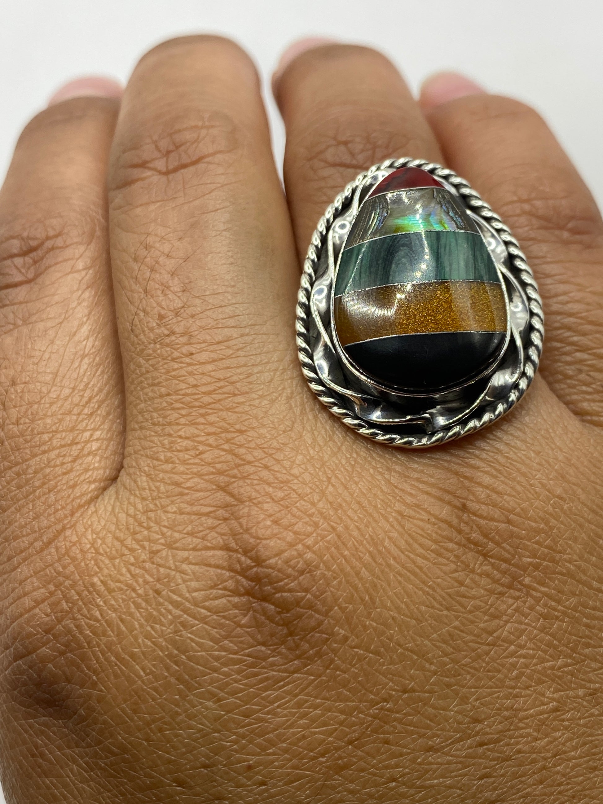 Anillo de malaquita puesto en dedo, mostrando sello 925 MEXICO y el verde profundo de la piedra