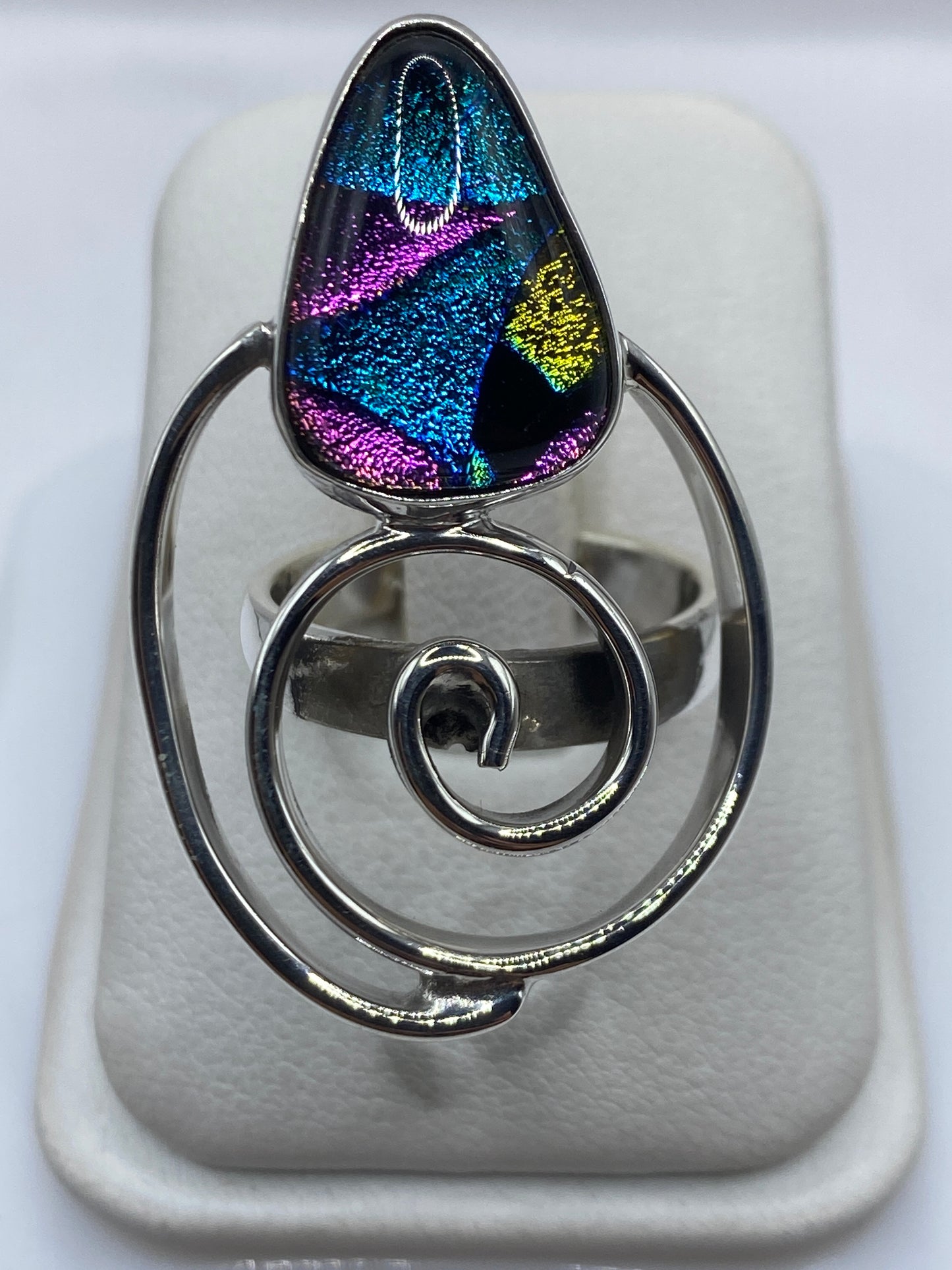 Anillo giratorio de plata .925 con piedras multicolor azul, magenta y dorado en la mano
