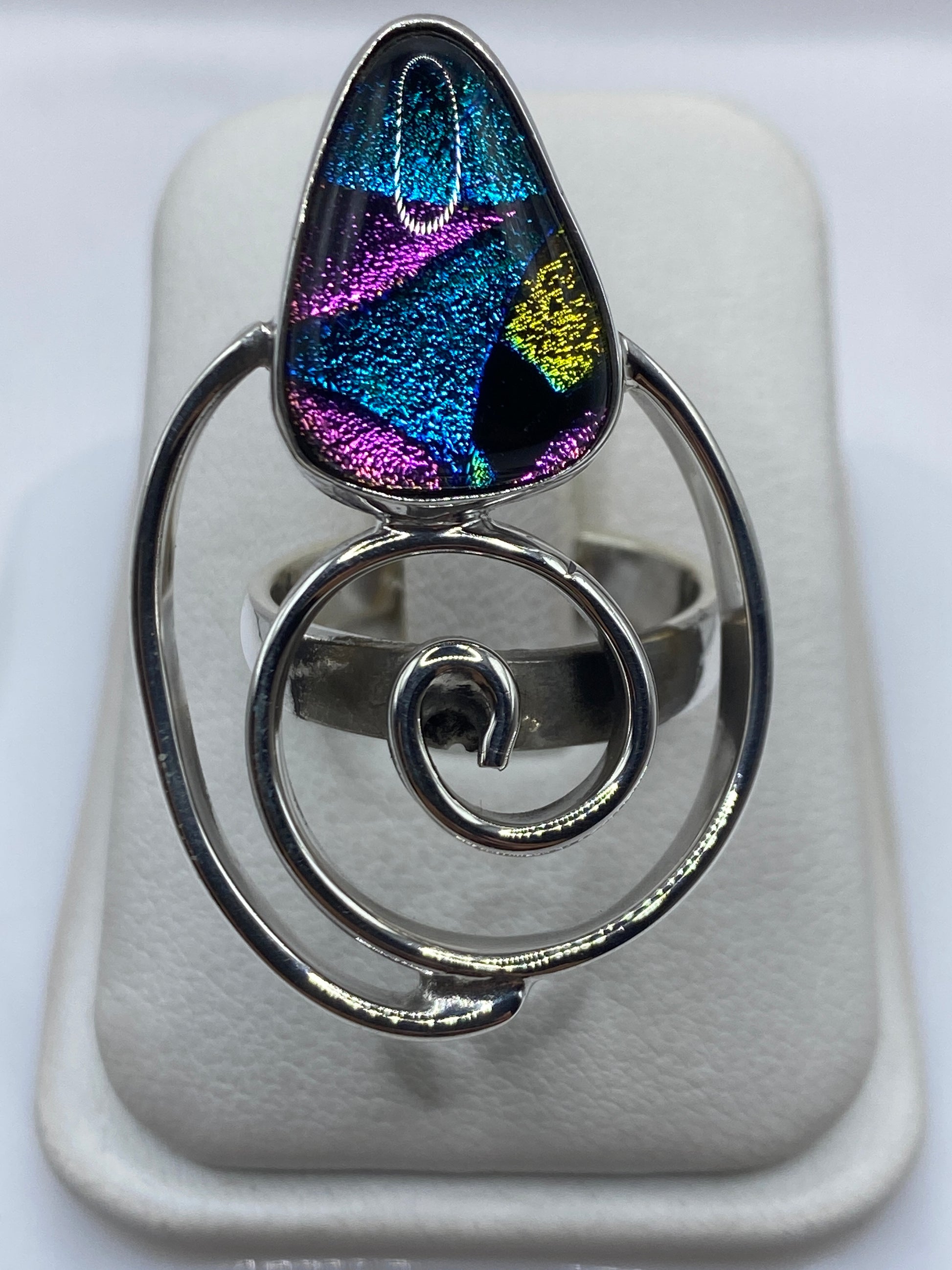 Anillo giratorio de plata .925 con piedras multicolor azul, magenta y dorado en la mano