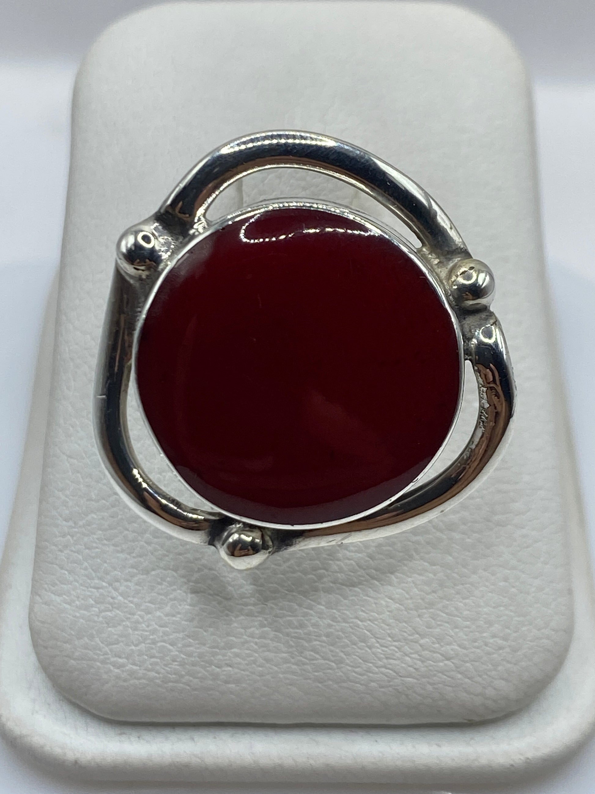 Anillo de plata ajustable con coral rojo natural en el dedo de una mujer