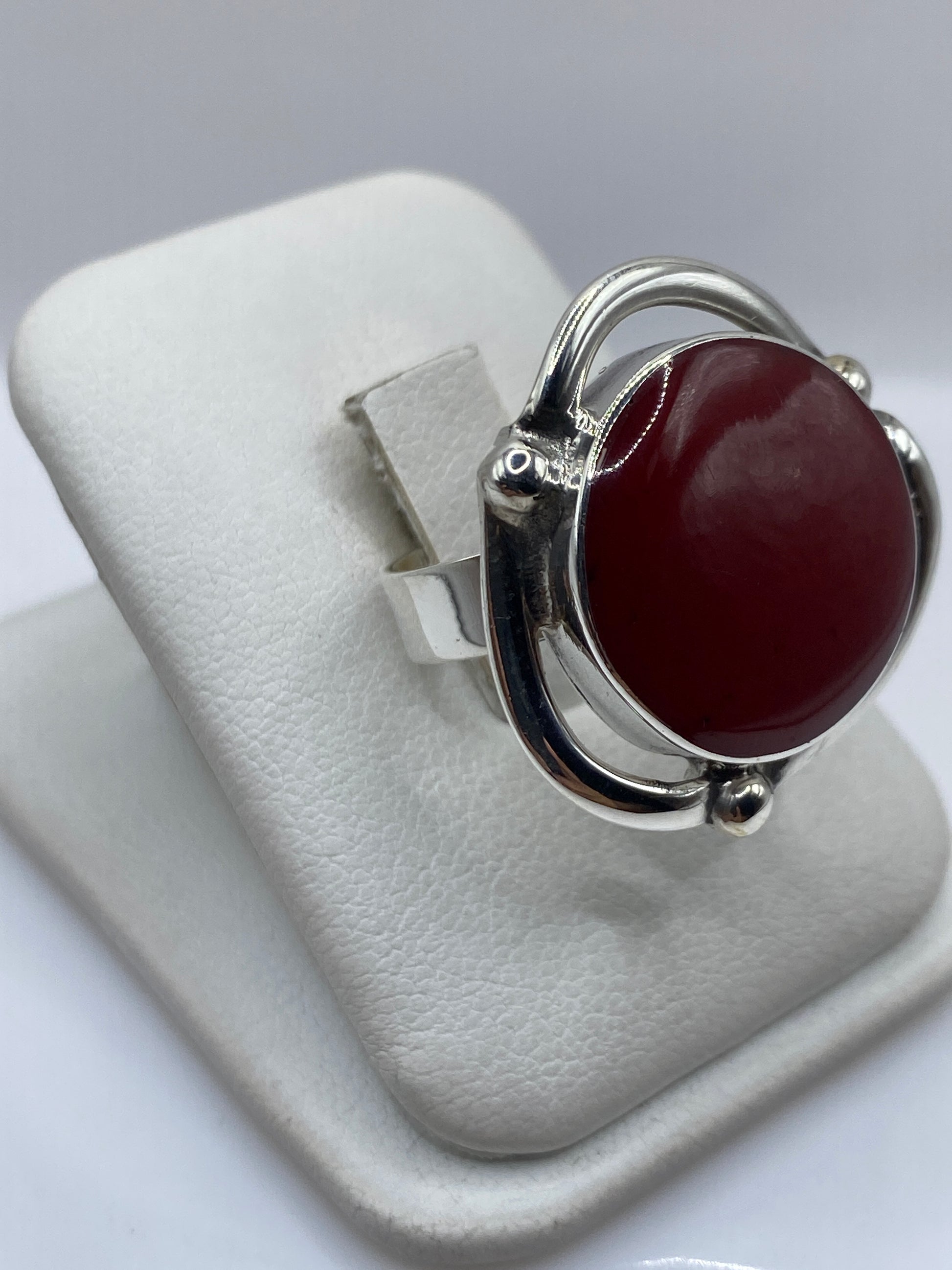 Vista frontal del anillo solitario de coral rojo en plata .925