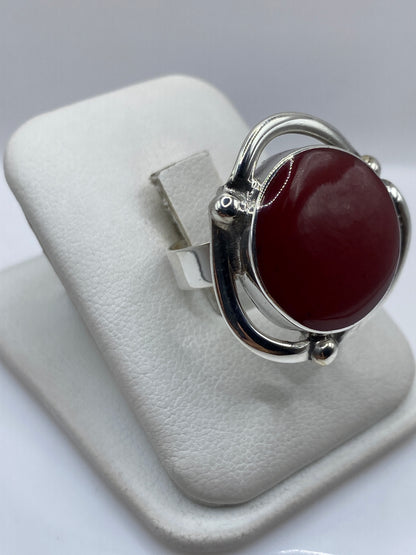 Vista frontal del anillo solitario de coral rojo en plata .925