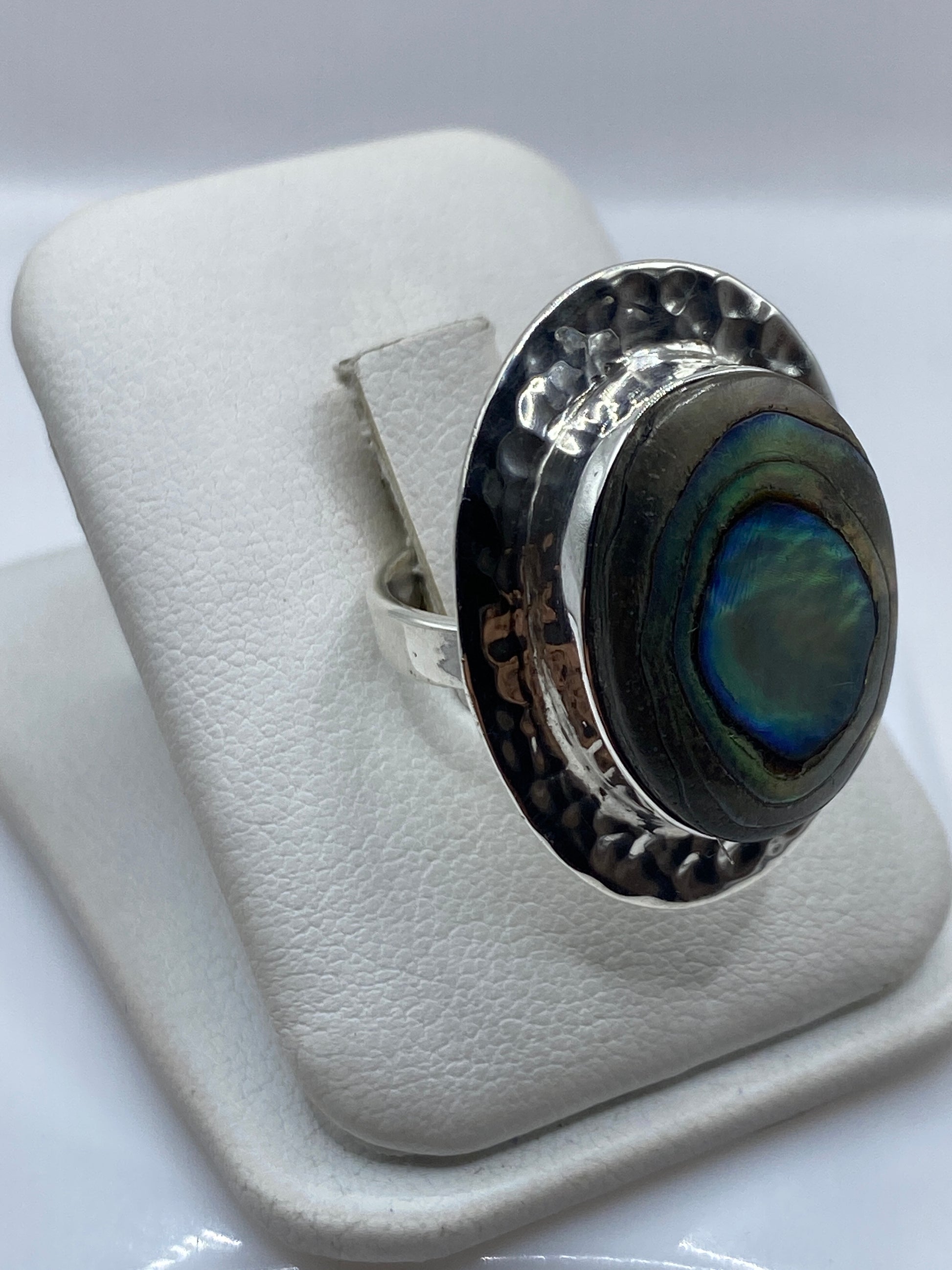 Anillo étnico en plata .925 sobre dedo femenino mostrando la iridiscencia natural de la piedra