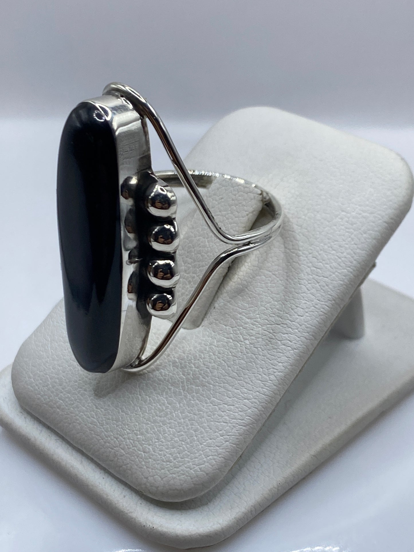 Anillo escultórico en mano de mujer mostrando el brillo espejo del ónix negro