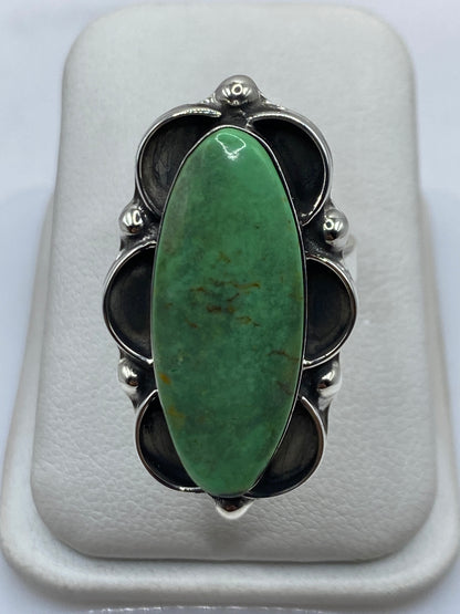 Anillo de plata con malaquita verde natural ajustable en la mano de una mujer