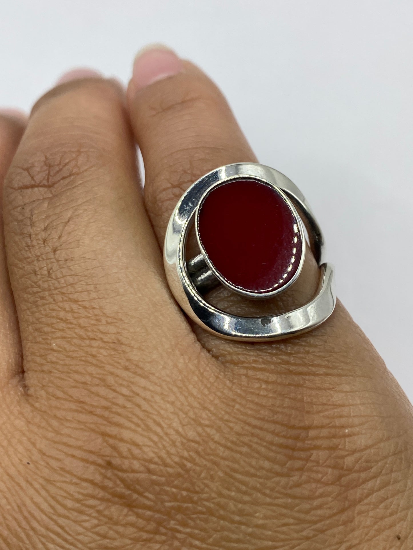 Anillo coral rojo sobre fondo blanco, vista superior con luz natural