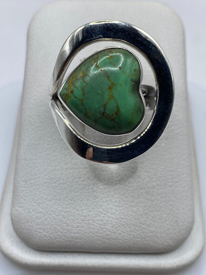 Anillo de plata solitario con turquesa verde natural en la mano de una mujer