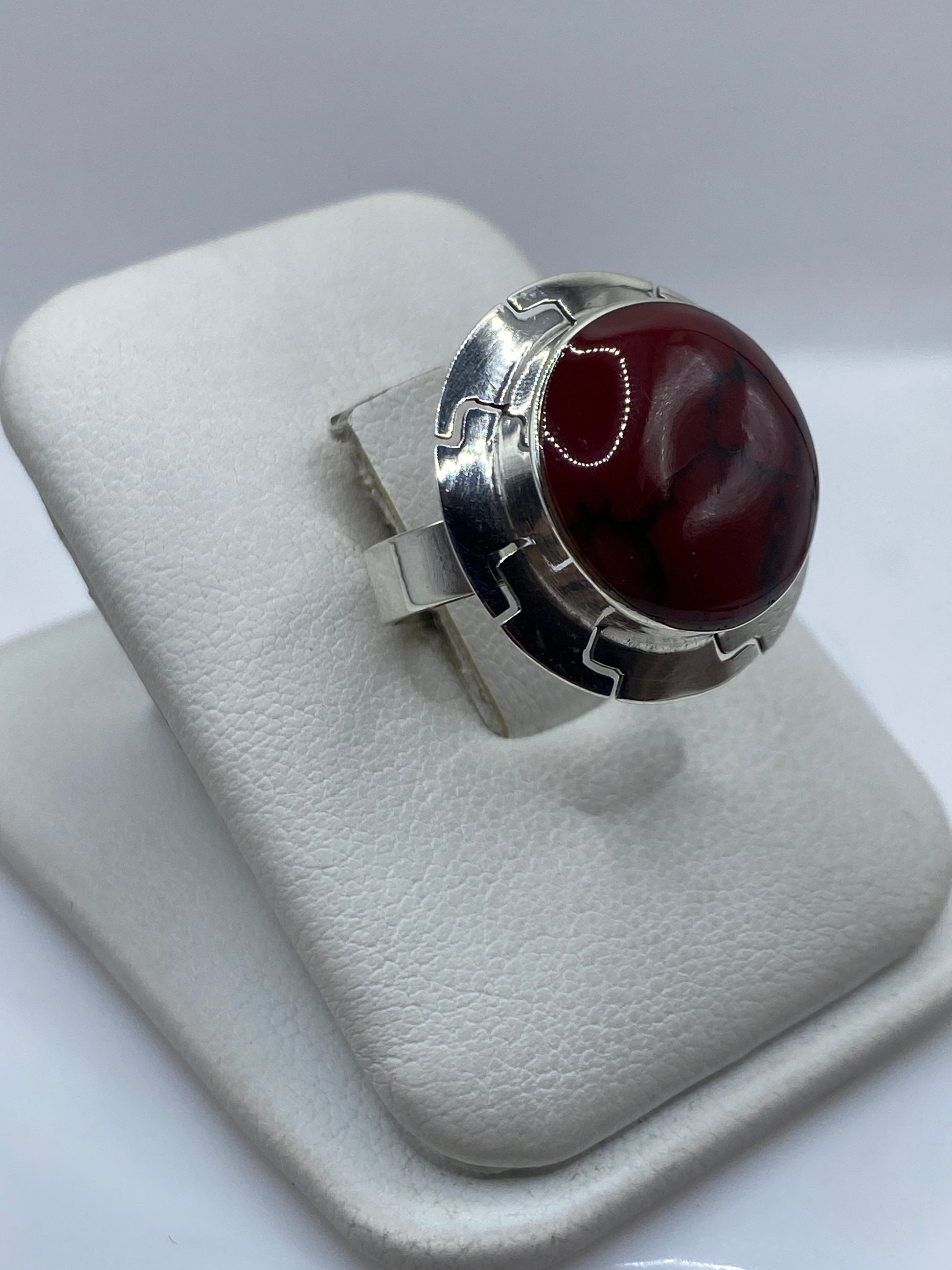 Anillo de plata .925 con coral rojo engastado, vista frontal sobre dedos