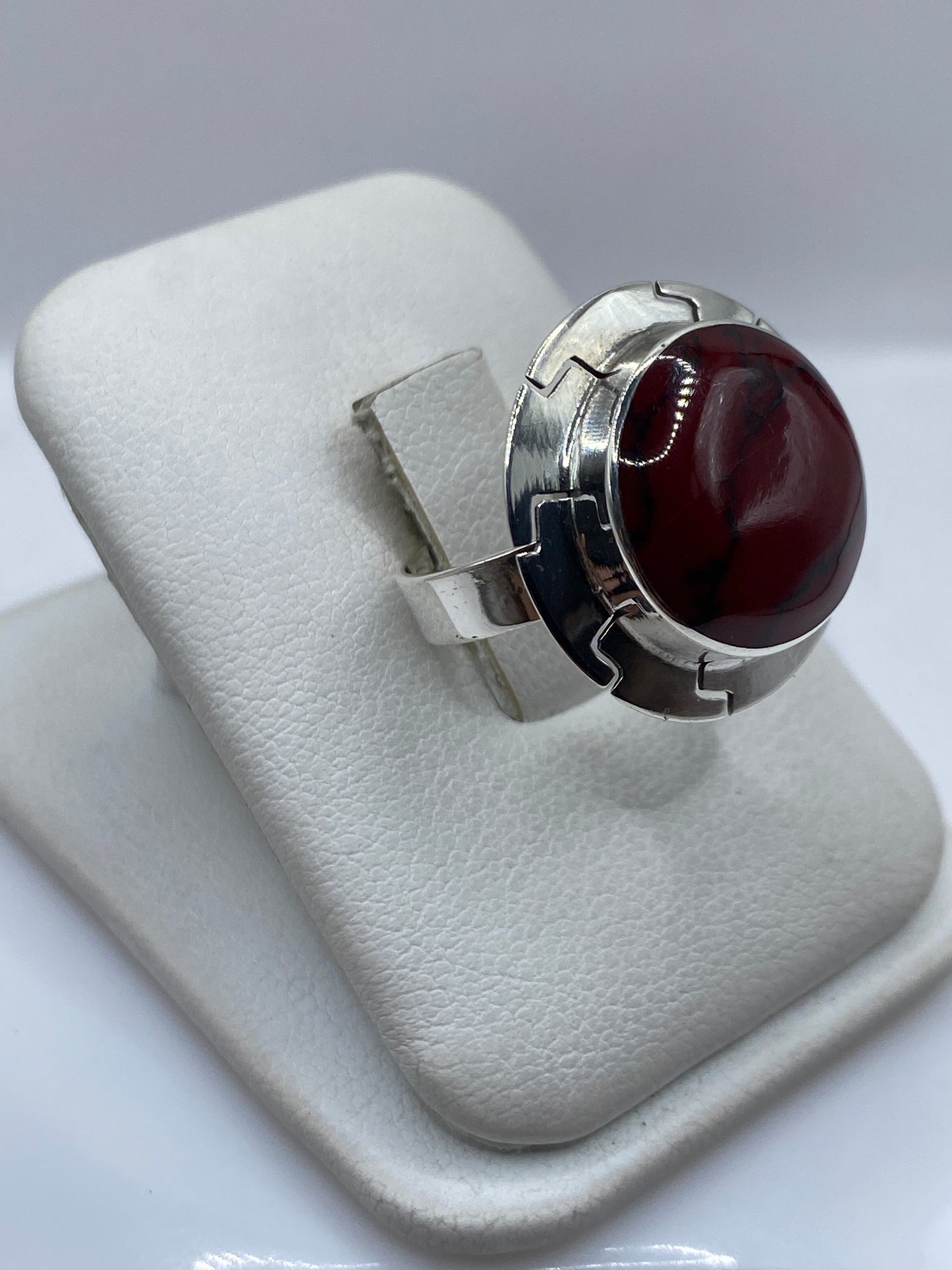 Vista lateral del anillo solitario de coral rojo con banda de plata .925