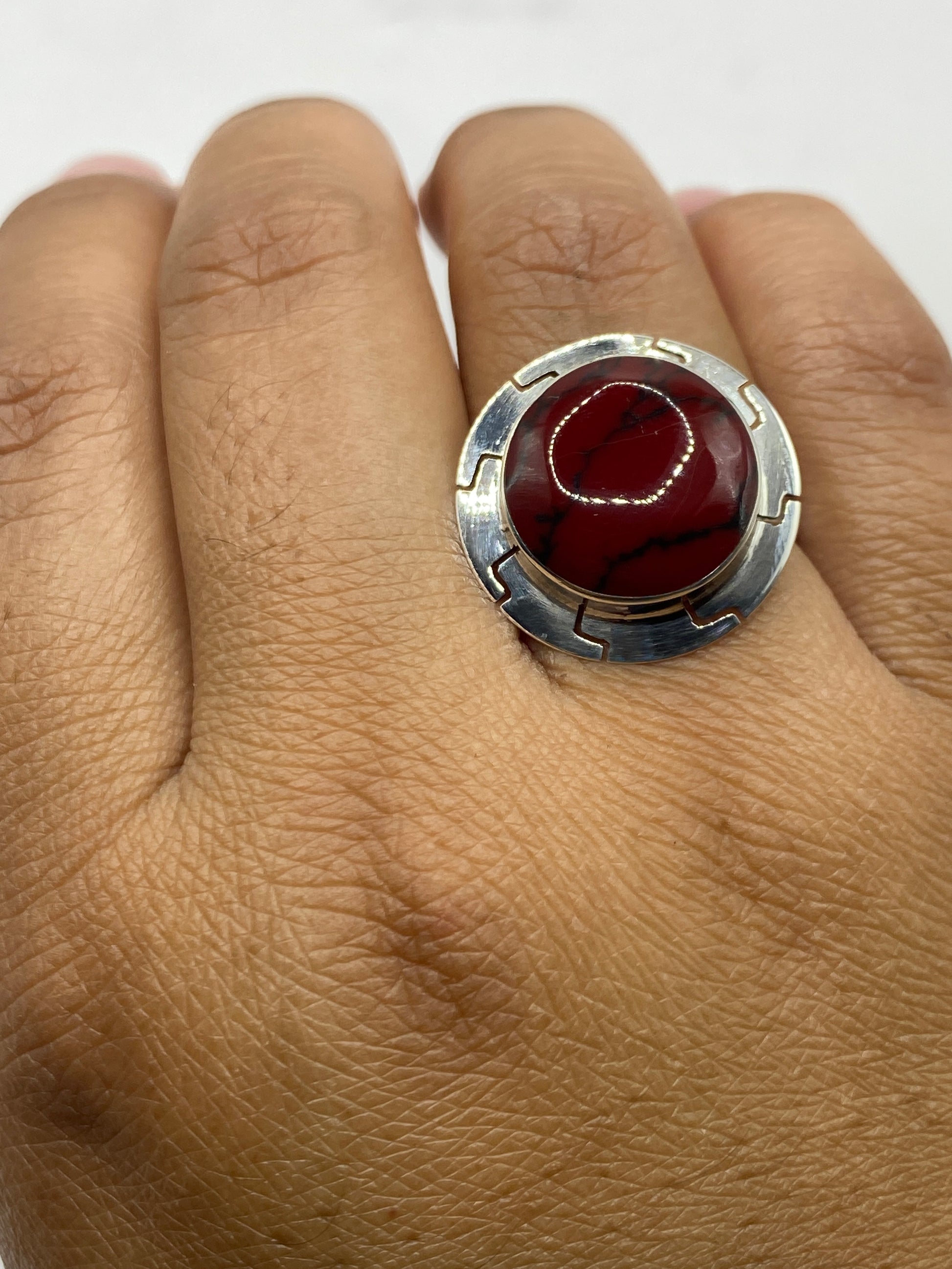 Anillo de coral rojo en mano mostrando ajustabilidad y brillo natural