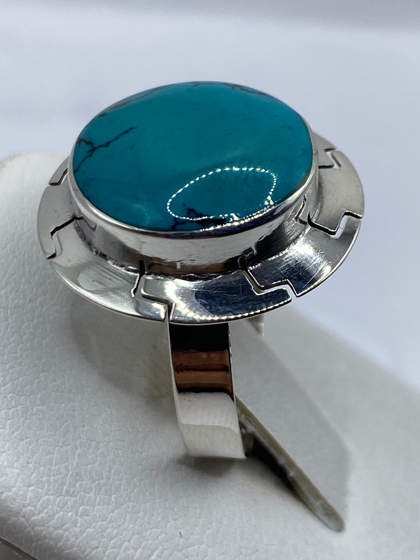 Anillo turquesa puesto en dedo, mostrando el color azul profundo con vetas naturales