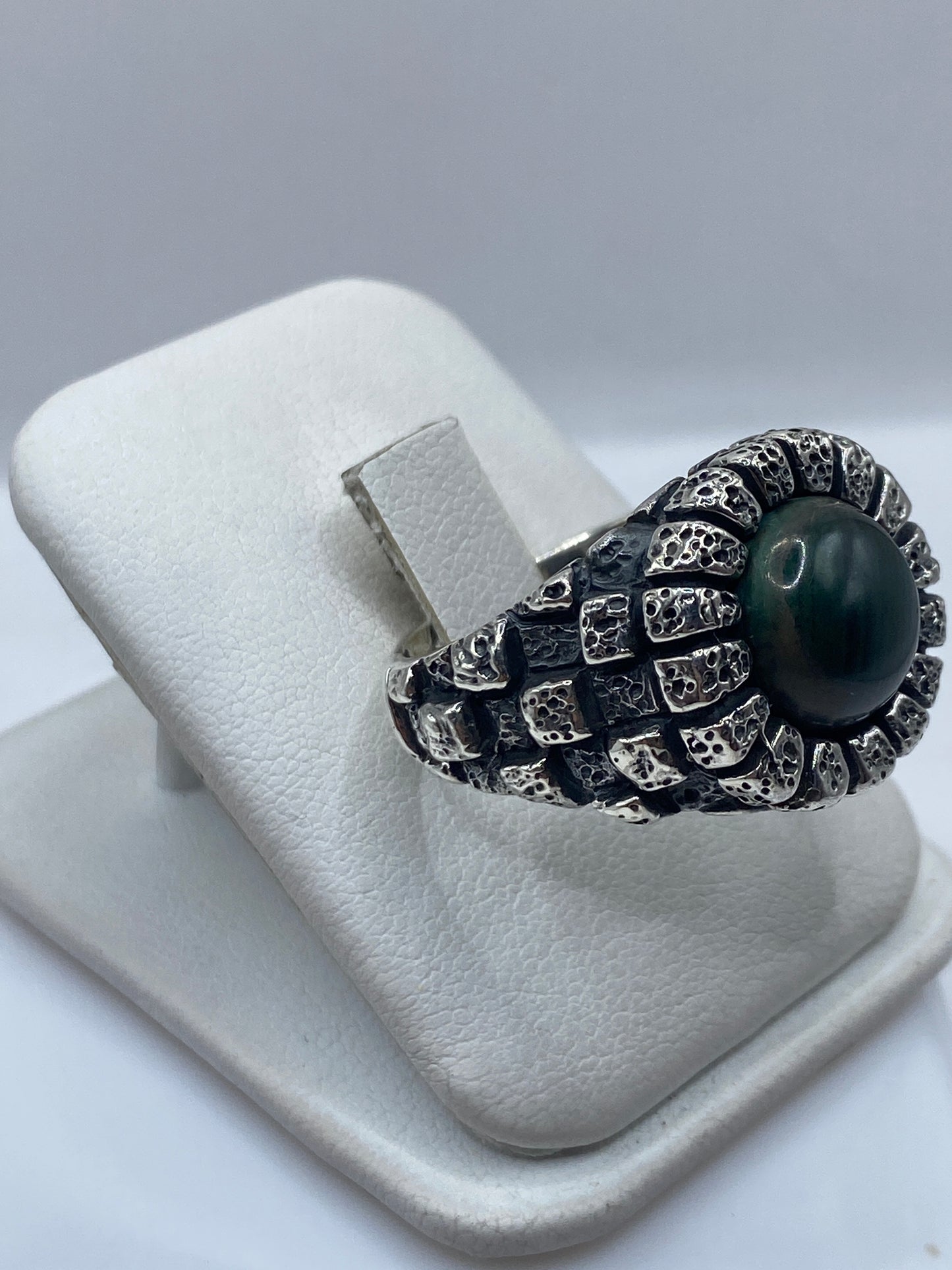 Detalle de la malaquita verde natural con vetas en anillo de plata