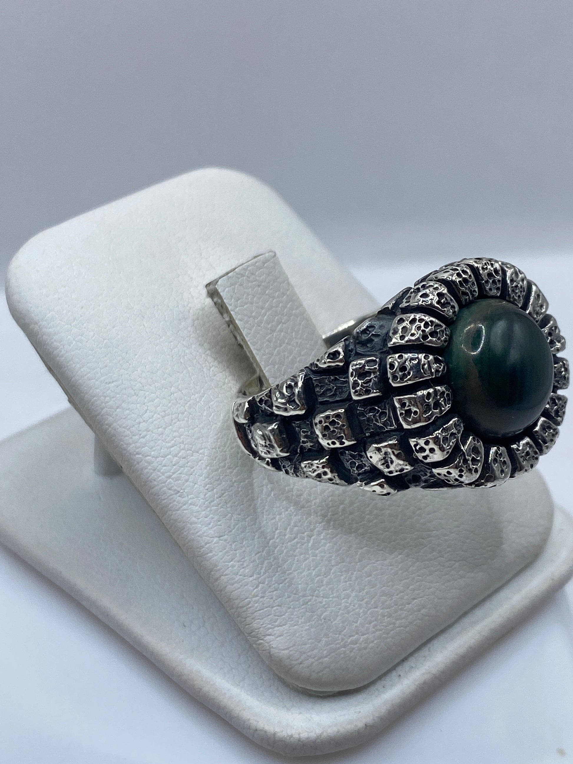 Detalle de la malaquita verde natural con vetas en anillo de plata