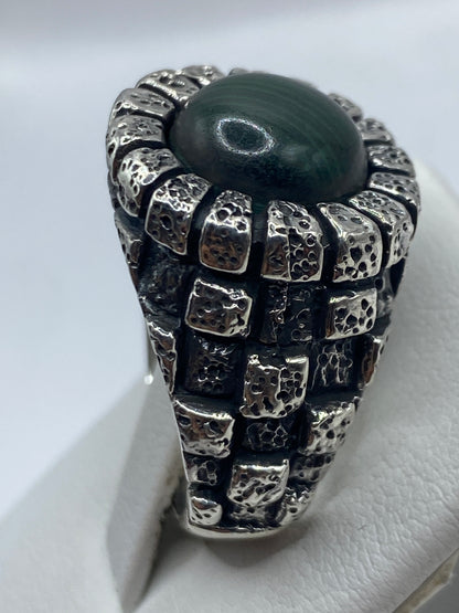Anillo malaquita verde en mano de hombre, mostrando presencia y peso
