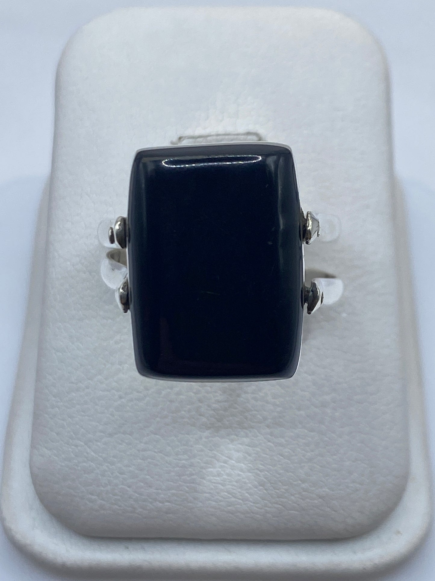 Anillo solitario de plata .925 con ónix negro en expositor blanco, vista frontal