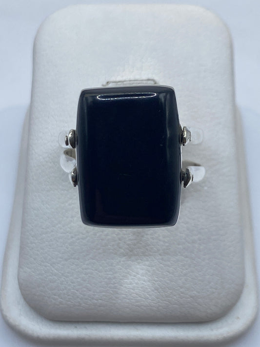 Anillo solitario de plata .925 con ónix negro en expositor blanco, vista frontal