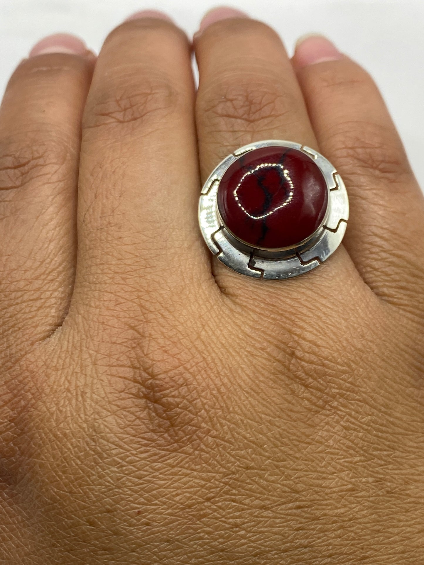 Anillo solitario de coral sobre fondo blanco, montura pulida en plata de Taxco