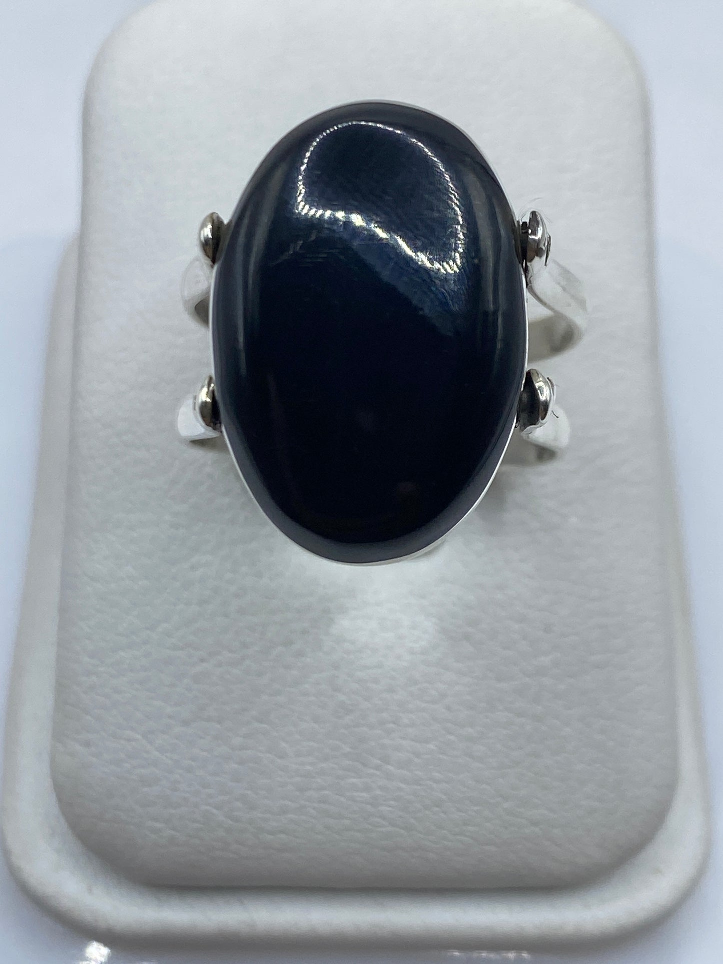 Anillo de plata turquesa visto lateralmente sobre mano de mujer, detalles del engaste