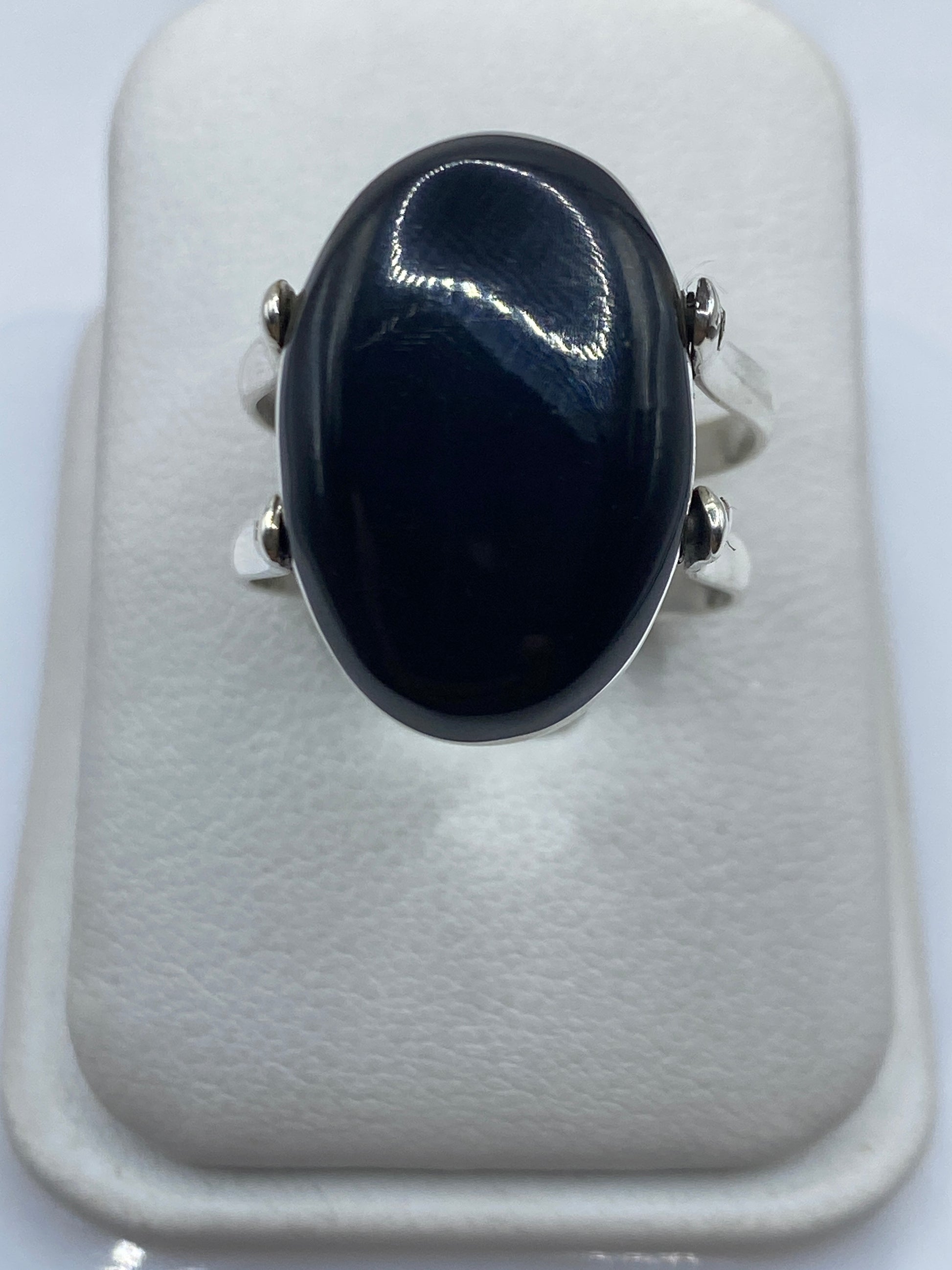 Anillo de plata turquesa visto lateralmente sobre mano de mujer, detalles del engaste
