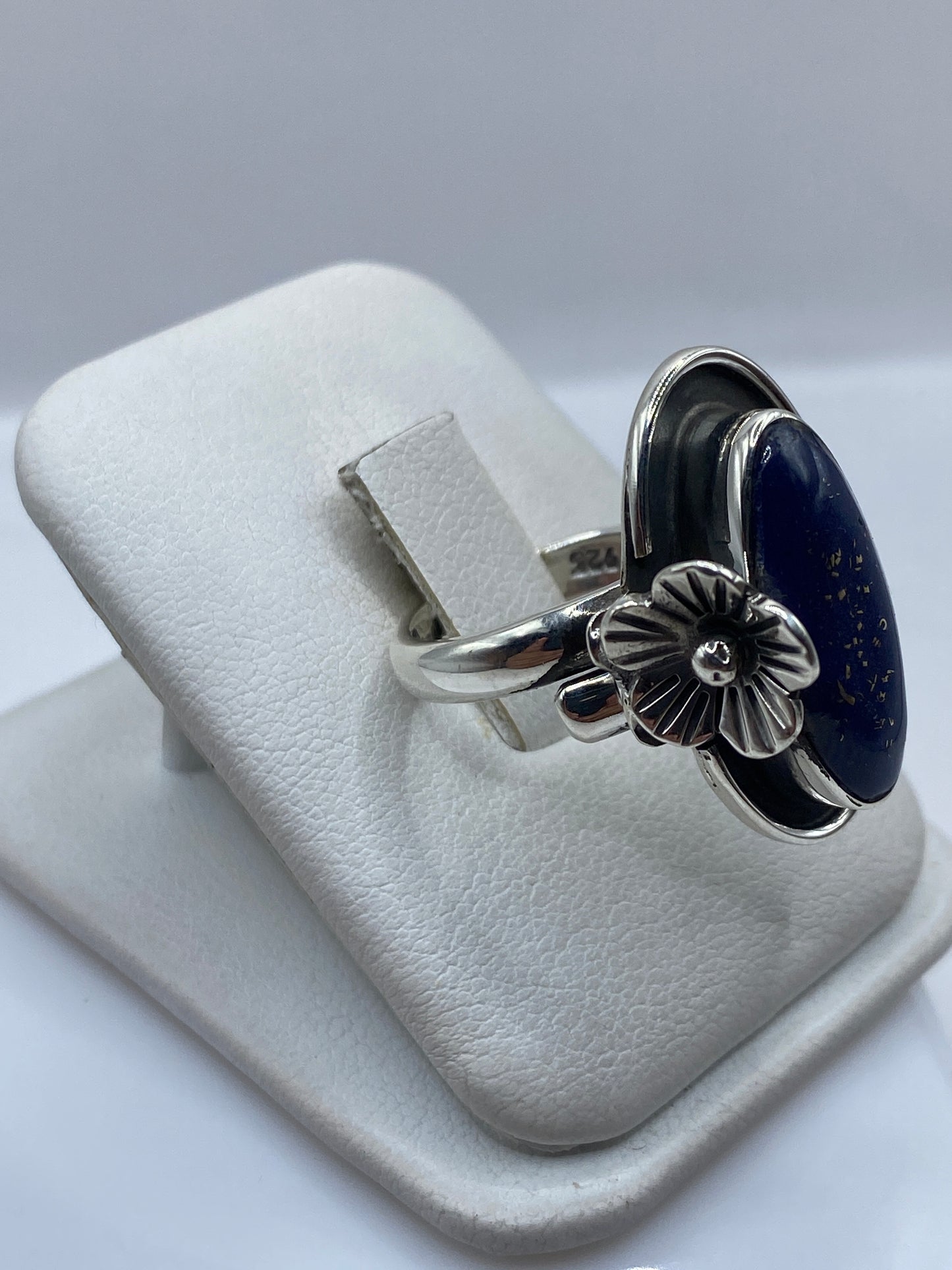 Vista lateral del anillo ajustable mostrando la flor en relieve y sello .925