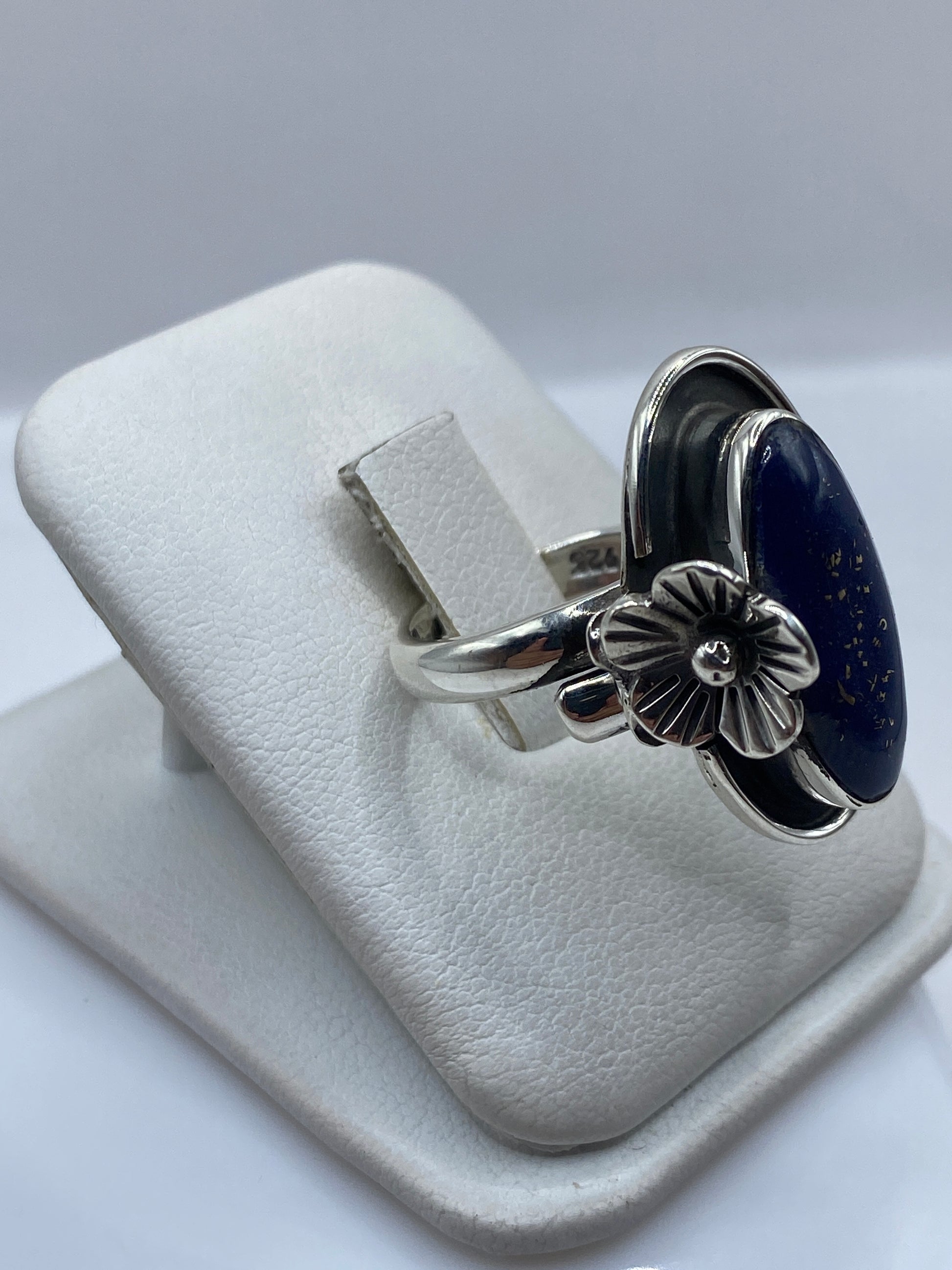 Vista lateral del anillo ajustable mostrando la flor en relieve y sello .925